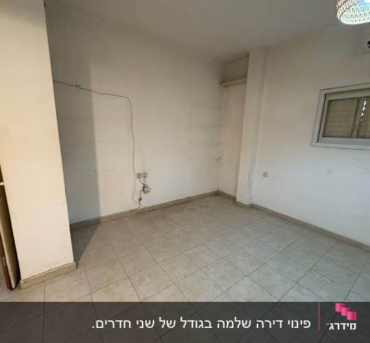 חדר ריק עם רצפת אריחים וקיר לבן